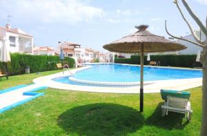 ein Regenschirm und eine Bank neben einem Pool in der Unterkunft B&B Nerja in Nerja