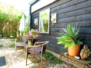 a patio with two chairs and a table with plants at 't Kasteeltje in Bergen