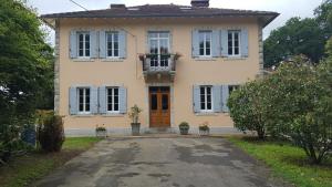a large yellow house with a door and windows at Maison Lalanne in Castelnau-Chalosse