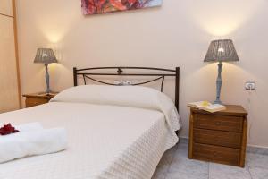 アルゴストリオンにあるKefalos Quiet Apartment In Argostoliのベッドルーム(白いベッド1台、ランプ2つ付)