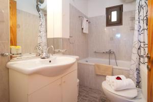 a bathroom with a sink and a toilet and a tub at Kefalos Quiet Apartment In Argostoli in Argostoli