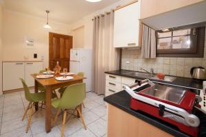cocina con fregadero y mesa con sillas en Dias Ground Floor Apartment, en Argostoli