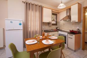 a kitchen with a wooden table and chairs in a kitchen at Dias Ground Floor Apartment in Argostoli