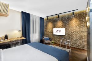 a bedroom with a bed and a brick wall at One Luxury Suites in Belgrade