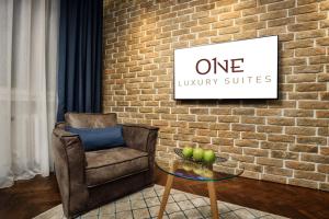 a chair and a glass table in front of a brick wall at One Luxury Suites in Belgrade