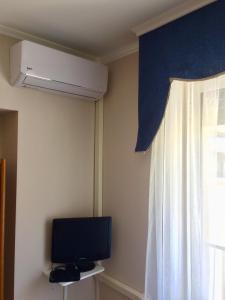 Una sala de estar con televisión y una ventana. en B&B CRISPI 53, en Agrigento