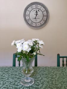 a vase of flowers sitting on a table with a clock at Casa Jolanda B&B in Palermo