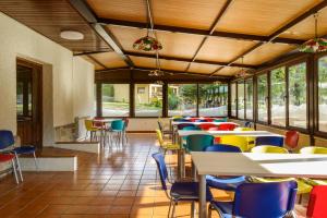 una cafetería con mesas, sillas y ventanas en Albergue Villanúa, en Villanúa