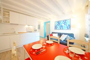 eine Küche und ein Esszimmer mit einem roten Tisch in der Unterkunft DolceVita Apartments N 426 in Venedig