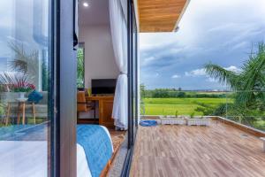 a room with a view of the countryside from a house at Hoi An Reverie Villas in Hoi An