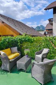 eine Terrasse mit 3 Stühlen, einem Sofa und einem Tisch in der Unterkunft Apartments and Rooms Banić in Kranjska Gora