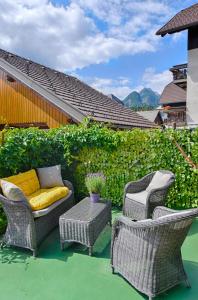 a patio with three chairs and a couch and a table at Apartments and Rooms Banić in Kranjska Gora