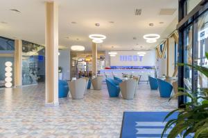 un hall avec des chaises bleues et blanches dans un magasin dans l'établissement West City Hotel, à Cluj-Napoca