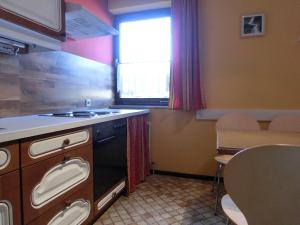 a kitchen with a stove and a sink and a window at Appartement Inge in Kaprun