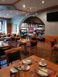 un restaurante con mesas y sillas de madera y un bar en Dahoam by Sarina - Rooms & Suites, en Zell am See