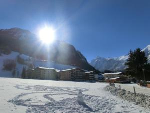 a snow covered mountain with the sun in the background at Appartement Inge in Kaprun
