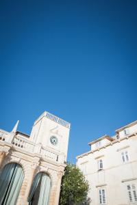 a clock tower on the side of a building at Yacht harbor apartment in Hvar