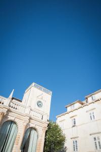 uma torre de relógio do lado de um edifício em Yacht harbor apartment em Hvar