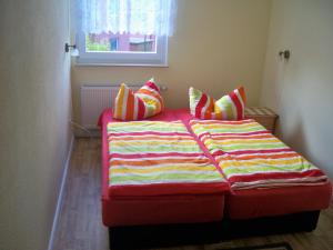 a bed with a colorful blanket and pillows on it at Meereswoge in Bansin