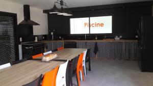 una sala da pranzo con tavolo, sedie arancioni e una presentazione di La Ry'Bambelle a Les Herbiers