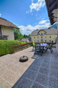 a patio with a table and chairs and a fire pit at Apartments and Rooms Banić in Kranjska Gora