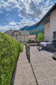 a patio with a wooden fence and a table and bench at Apartments and Rooms Banić in Kranjska Gora