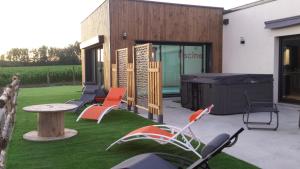 a patio with chairs and a table and a grill at La Ry'Bambelle in Les Herbiers +2 photos