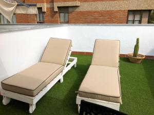 2 sillas en un patio con césped verde en SevillaHome - Marqués de Paradas, en Sevilla