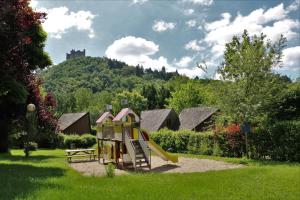 un parco giochi con scivolo e un castello su una collina di Camping Le Païsserou a Najac