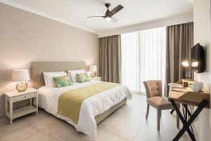 a hotel room with a bed and a desk and a chair at Cesca's Boutique Hotel in Xlendi