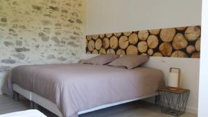 a bedroom with a bed with a wooden headboard at La Ry'Bambelle in Les Herbiers