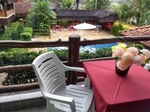 une table avec un tissu de table rouge et un vase de fleurs dans l'établissement RC Sol de Boiçucanga - Suite, à Boicucanga