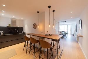 a kitchen and dining room with a wooden table and chairs at Petit Luxe l'Àtic in Terrassa +40 photos