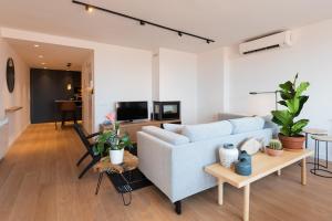 a living room with a couch and a table at Petit Luxe l'Àtic in Terrassa