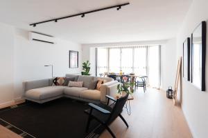 a living room with a couch and a table at Petit Luxe l'Àtic in Terrassa