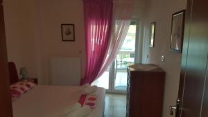 ケラモティにあるGeorge and Mary's Houseのベッドルーム1室(ベッド1台付)、ピンクのカーテン付きの窓が備わります。