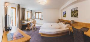a hotel room with a bed and a desk at Hotel Montfort in Sankt Anton am Arlberg