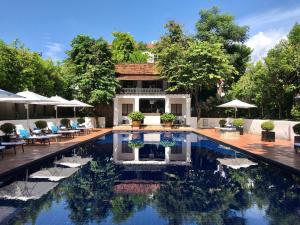 a swimming pool in front of a house at Rachamankha Hotel in Chiang Mai