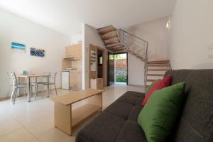 a living room with a couch and a table and a staircase at Spela House in Agioi Apostoli