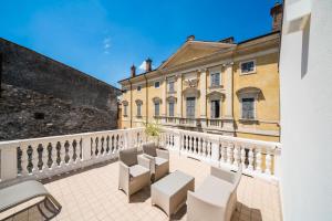 een balkon met witte stoelen en een gebouw bij Corte Vale Dium in Valeggio sul Mincio