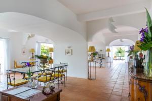 a living room with a table and yellow chairs at Hotel Piccolo Sant'Andrea in Praiano