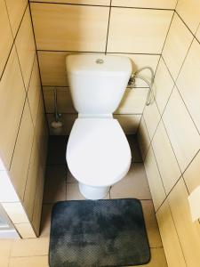 a toilet in a small bathroom with a black rug at Apartament u Doroty in Augustów