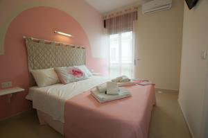 卡斯特拉巴特VILLA PASCALE - B&B - CASA VACANZE的一间卧室配有一张带粉红色床头板的床