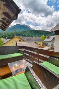 einen Balkon mit einem Tisch, Stühlen und Bergen in der Unterkunft Apartments and Rooms Banić in Kranjska Gora