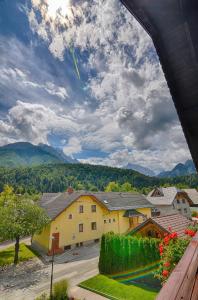 einen Blick auf ein Haus mit Bergen im Hintergrund in der Unterkunft Apartments and Rooms Banić in Kranjska Gora