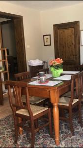 una mesa de comedor de madera con sillas y flores. en Appartamenti San Rocco en Montefalco