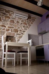 cocina con mesa blanca y pared de piedra en Apartment Cukarin A2 BOL-CENTER, Croatia en Bol