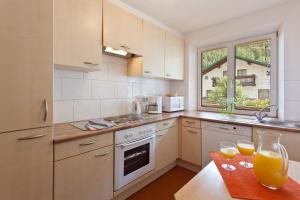 a kitchen with a table with two glasses of orange juice at Hotel Montfort in Sankt Anton am Arlberg