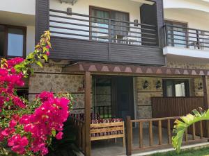 a house with a balcony and pink flowers at Sedir Park - Beach Bungalow in Kargicak