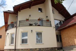 a building with a balcony with flowers on it at Popasul Călătorului in Moisei